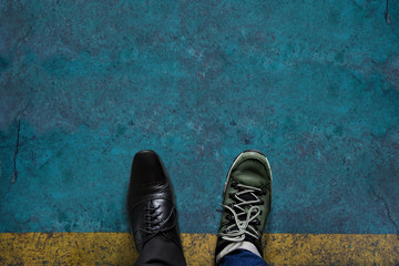 Wall Mural - Life Balance Concept for Work and Travel present in top view position by half of Business Oxford and Adventure shoes, Grunge Cement Floor as background