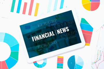 Wall Mural - financial news, splash screen on tablet pc over business charts