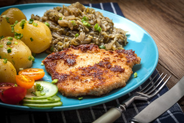 Wall Mural - Fried pork chop, baked potatoes and fried young cabbage.