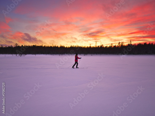 Woman In Red Jacket Skiing On Frozen Lake In Lapland - 