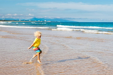 Wall Mural - Child on tropical beach. Sea vacation with kids.