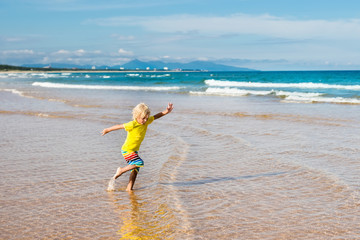 Wall Mural - Child on tropical beach. Sea vacation with kids.