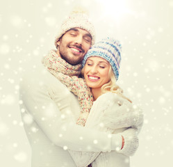 Canvas Print - smiling couple in winter clothes hugging