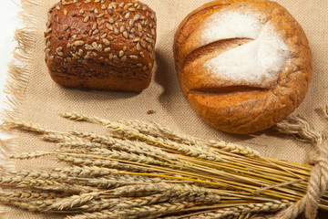 Rustic Bread and wheat on a white wooden background