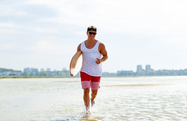 Wall Mural - happy young man with skimboard on summer beach