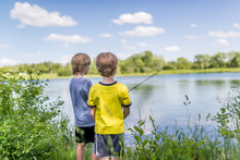 Two Boys Fishing On The Lake