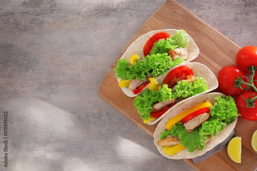 Holder with delicious fish tacos on wooden board
