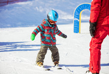 Young Skier And Ski Instructor On Slope In Beginners' Area