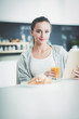 © lenets_tan - Young woman with orange juice and tablet in kitchen.