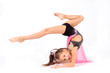 Flexible little girl gymnast doing acrobatic exercise on white background