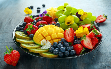 Wall Mural - Colorful Mixed Fruit platter with Mango, Strawberry, Blueberry, Kiwi and Green Grape. Healthy food