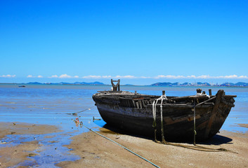 Naklejka na meble An old wooden boat at a sea shore
