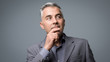 © stokkete - Smart businessman thinking with hand on chin
