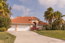 Typical Southwest Florida Concrete Block And Stucco Home In The Countryside With Palm Trees, Tropical Plants And Flowers, Grass Lawn And Pine Trees. Florida