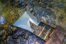 Prospecting For Gold Using Sluice Box. Gold Panning And Mining In Riverbed. Fun And Adventure Of Recreational Activity Of Gold Panning And Gem Mining.