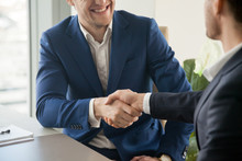 Businessman In Blue Suit Handshaking At Business Meeting, Trying To Make Positive First Impression On Partner At Negotiation, Welcoming New Colleague In Office. Successful Partnership, Close Up