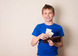 Finances, childhood, teen and savings concept. Happy teen boy with purse and paper rubles money.