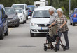 Seniorenpaar am Rollator überquert die Straße