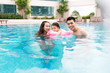 © makistock - Happy family in swimming pool. Summer holidays and vacation concept