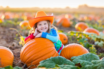 child playing on pumpkin patch