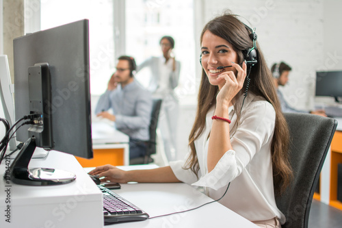 Fotografía Young friendly operator woman agent with headsets working in a call centre