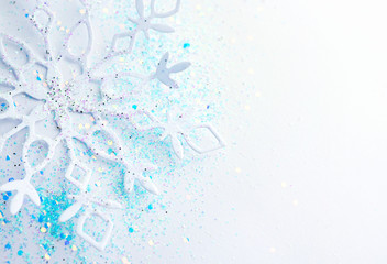Wall Mural - light blue white christmas and new year background. snowflake in sequins close-up macro with a soft 