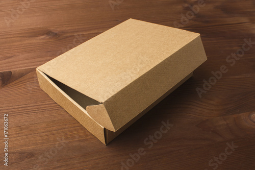 Fotografía Cardboard box on a dark, wooden background. Corrugated cardboard