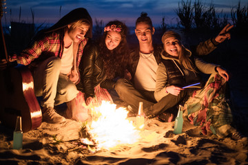 Hippie friends with guitar near bonfire