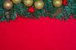 © Thiago Santos - Ótimo fundo de natal vermelho com folhas verdes de pinheiro e objetos decorativos de celebração natalina