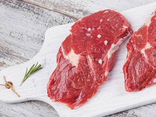 Raw fresh beef steak on a white cutting board