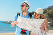 © FS-Stock - Multiethnic traveler couple using generic local map together on sunny day.
