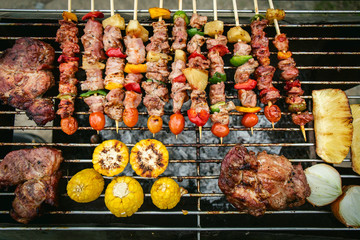 BBQ grill with pork and vegetable on fire.