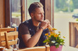 © Fxquadro - A man sits at the table in a cafe.