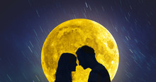 Silhouettes Of A Young Couple Under The Starry Sky With Full Moon. 