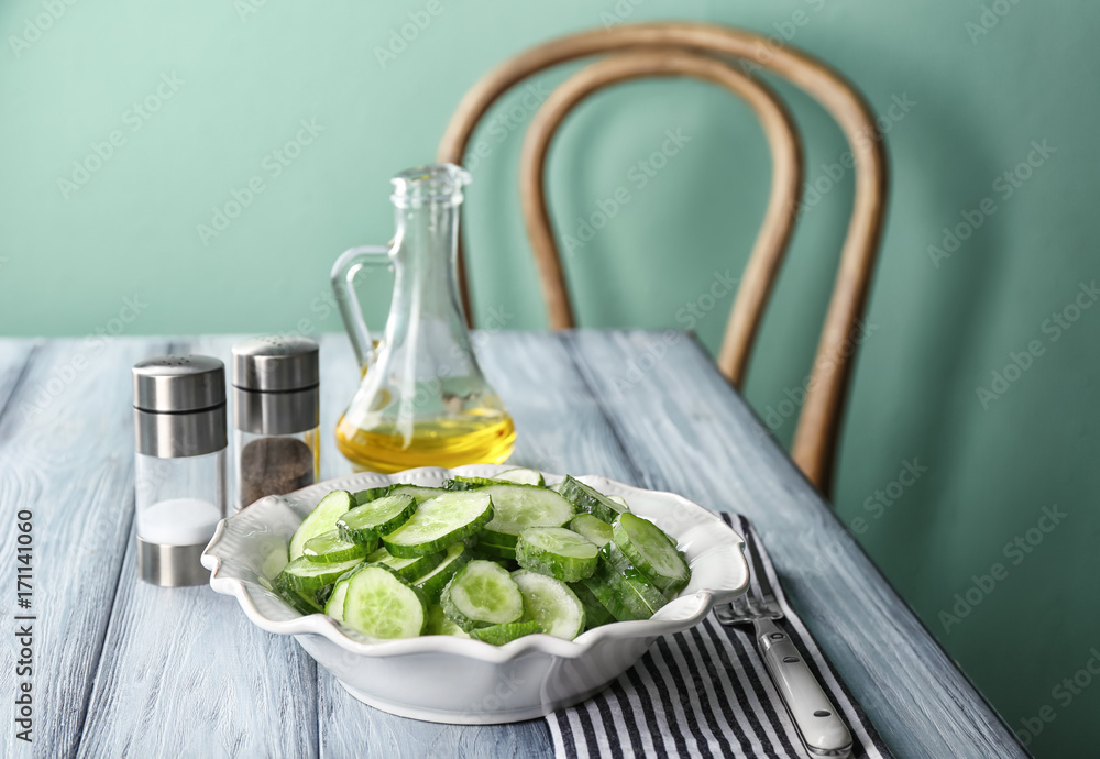 Slices of cucumber in plate on table