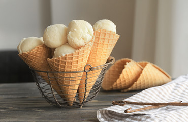 Wall Mural - Metal basket with delicious waffle cones of vanilla ice-cream on table