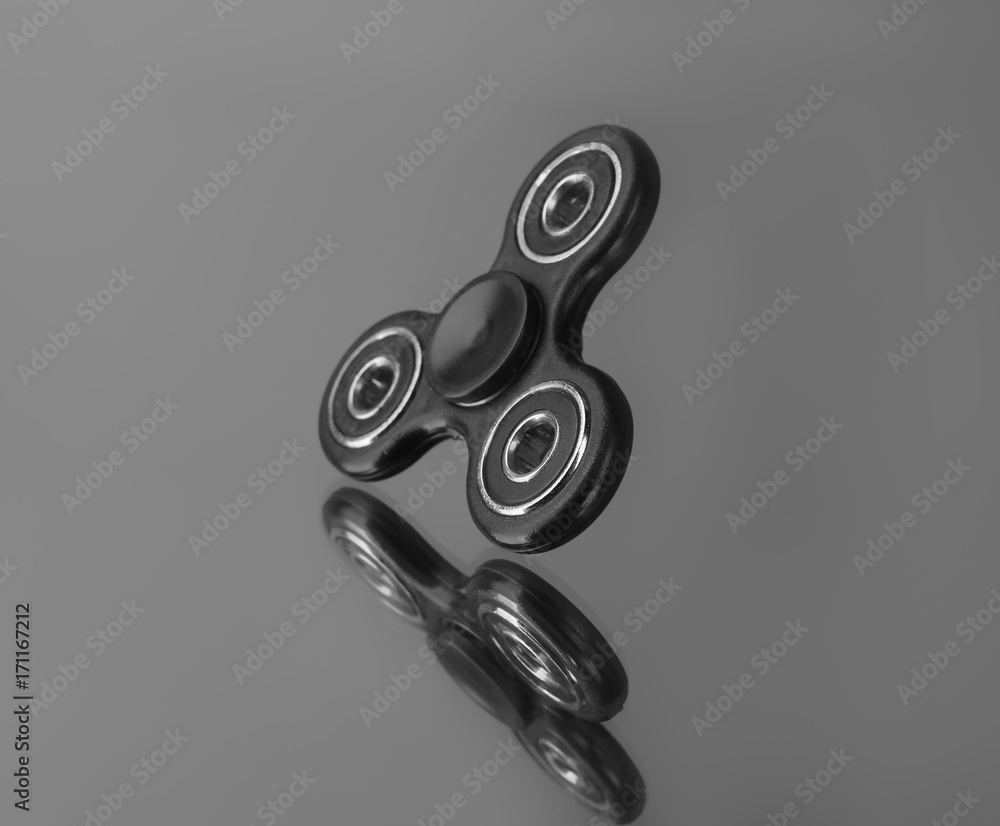 Modern spinner on mirror background