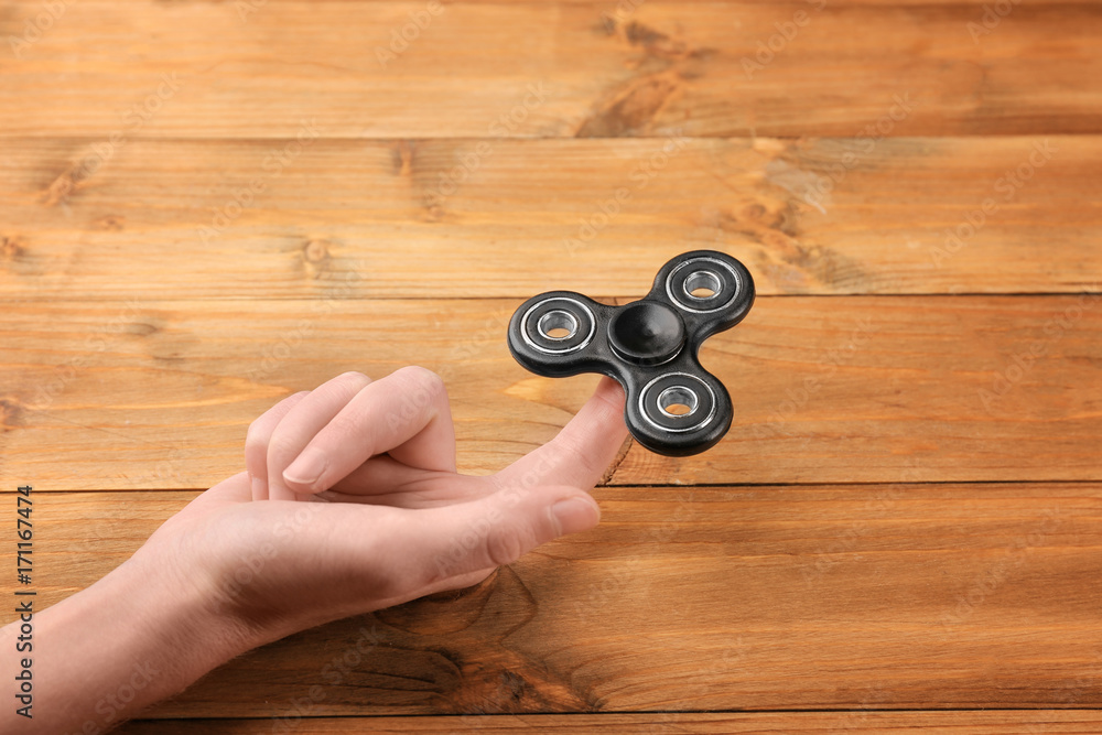 Woman rolling modern spinner on wooden background