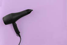 Black Hair Dryer On Lilac Paper Background