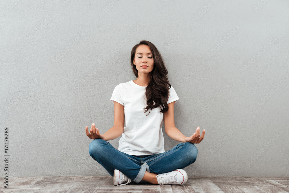 Beautiful young asian woman sitting in yoga position and meditating ...