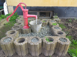 Red hand pump and bucket