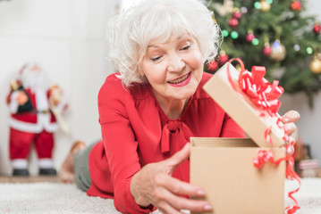 Cheerful mature female is looking in box