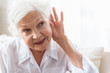 © Yakobchuk Olena - Old lady is having difficulty with auditory perception