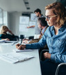 © Jacob Lund - Young businesswoman writing notes during presentation