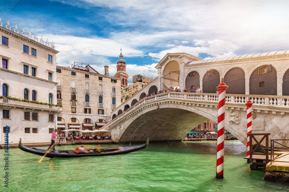 Die Rialto Brücke in Venedig, Italien, mit vorbeifahrender Gondel - obrazy, fototapety, plakaty 