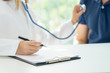 © petzshadow - Doctor examining pulse of patient by stethoscope, medical diagnosis concept.