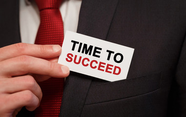 businessman putting a card with text time to succeed in the pocket