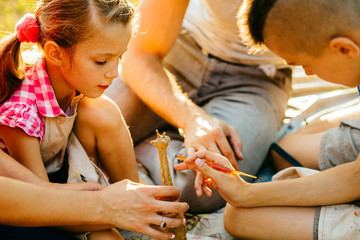 Wall Mural - Happy mother, father and two kids are painting in the park. The concept of a happy family.