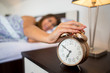 © Marko - Woman turning off alarm clock in the morning closeup