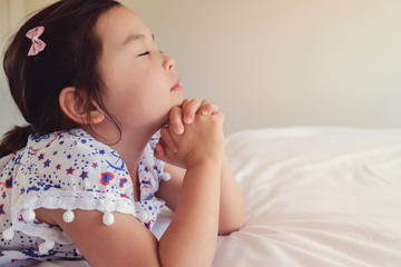 Wall Mural - asian little girl praying on the bed